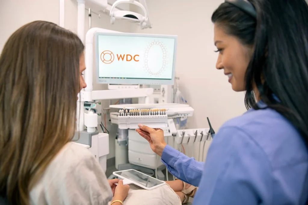 Dentist Showing A Patient Tooth Shade Options Beside A Chairside Screen At Warragul Dental Care
